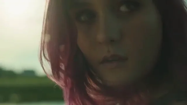 A close-up of a young woman with pink hair from the Savage Youth trailer