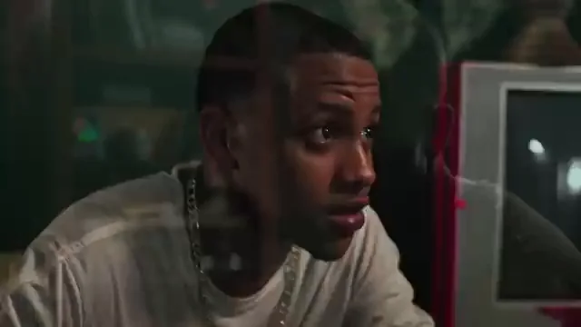 A young man speaks in a dimly lit room in a still from the Savage Youth trailer